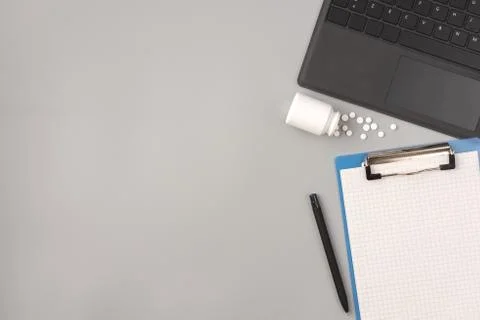 Work stress concept. Workspace desk with pharmaceutical pills, laptop, notepa Stock Photos