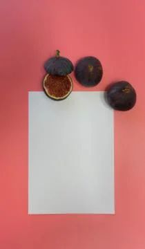 Work table with blank sheets and pen, sliced fresh juicy figs, pink backgroun Stock Photos