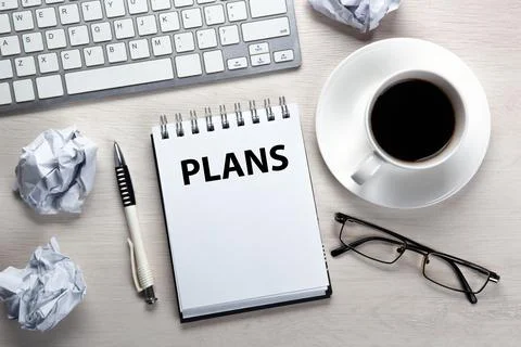 Work table, a cup of coffee, a notebook with a pen and crumpled paper Stock Photos