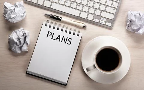 Work table, a cup of coffee, a notebook with a pen and crumpled paper Stock Photos