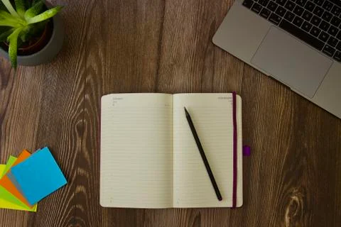 Work table with laptop, diary and colourful note sheets Stock Photos
