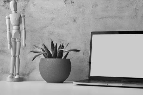 Work table with laptop with white clean screen, flower and wooden drawing figure Stock Photos