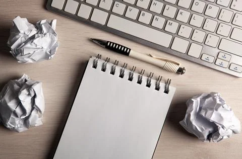 Work table, a notebook with a pen and crumpled paper Stock Photos