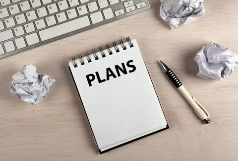 Work table, a notebook with title plans a pen and crumpled paper Stock Photos