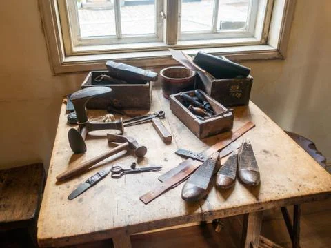Work table with old tools of the artisan shoemaker at the interior of the Han Stock Photos