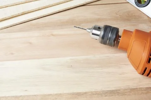 Work table, orange electric drill on a wooden table Foto stock