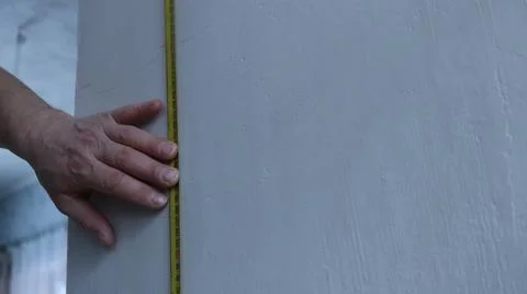 Work with a tape measure on a wall surface indoor Stock Photos