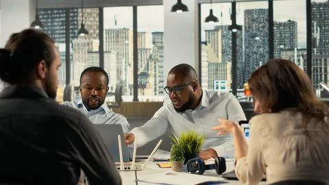 Work team engaged in negotiation and project consulting during business meeting Stock Photos