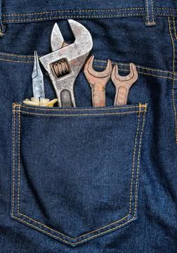 Work tool in the back pocket of the jeans. Pliers, wrench, adjustable wrench. 库存照片