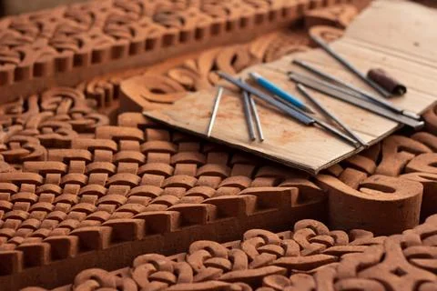 Work tools, gravers, chisels lies on red brick religious slab with pattern Stock Photos