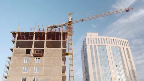 The work of a tower crane in the construction of an apartment building. Vidéo 143117875