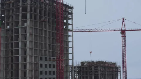 The work of a tower crane on the construction of a house Stock Footage 231695022