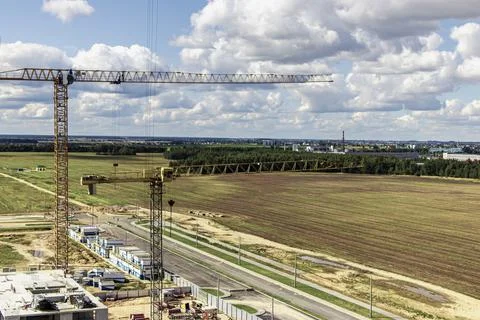 The work of tower cranes against the background of the sunset sky Photos