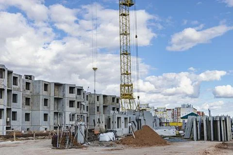 The work of tower cranes against the background of the sunset sky. Photos
