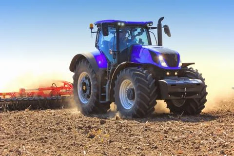 Work of a tractor on a wheat field  . Field of tractor plowing. Stock Photos