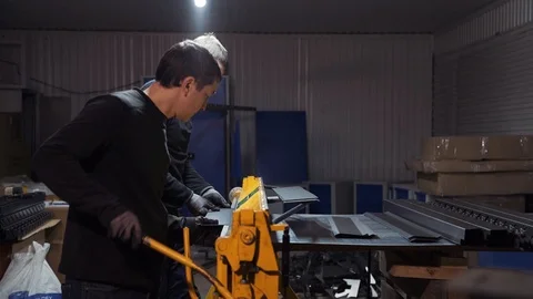 The work of two people behind the machine for the production of metal fences. Stock Footage 108648704