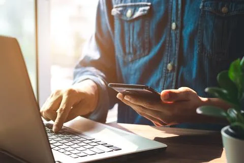 Work using mobile phone typing computer mobile chat laptop contact us at work. Stock Photos