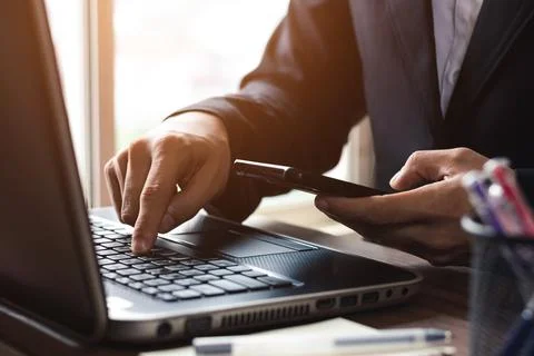 Work using mobile phone typing computer mobile chat laptop contact us at work Stock Photos