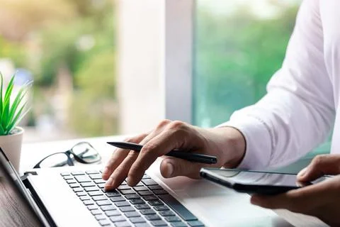 Work using mobile phone typing computer mobile chat laptop contact us at work Stock Photos