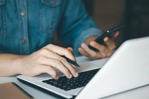 Work using mobile phone typing computer mobile chat laptop contact us at work Stock Photos