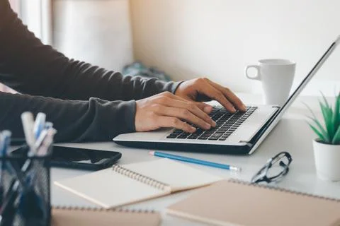 Work using mobile phone typing computer mobile chat laptop contact us at work Stock Photos