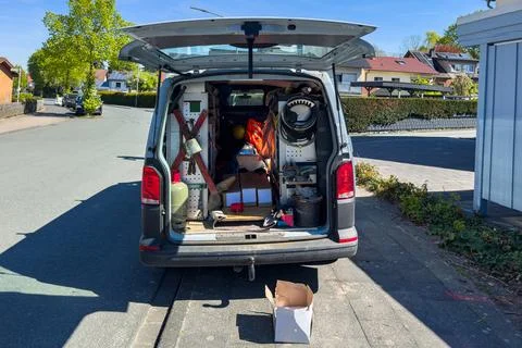 Work van with tools and equipment visible parked on a street 스톡 사진