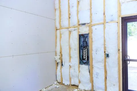 Work on wall insulation electrical panel in home during renovation at Stock Photos