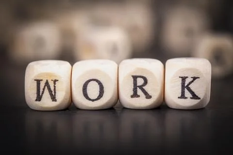 Work word made with building blocks. Work on wooden cubes on grey notepad. .. Stock Photos
