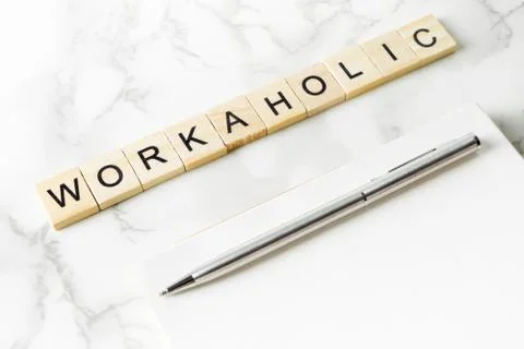Workaholic text on marble office table with copy space on notebook Stock Photos