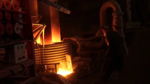 Worker adds coil into the fire during the steel melting process Stock Footage 72762777