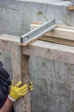 Worker adjust level of wooden framework installation Stock Photos