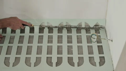 Worker Adjusting Size of Foam Underlayment Sheet Near Wall Stock Footage 322055641