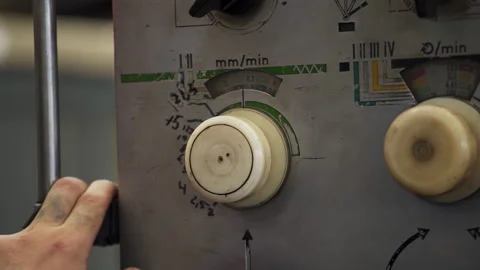 Worker adjusting speed and feed rate on industrial machine control panel. Stock Stock Footage 312080166