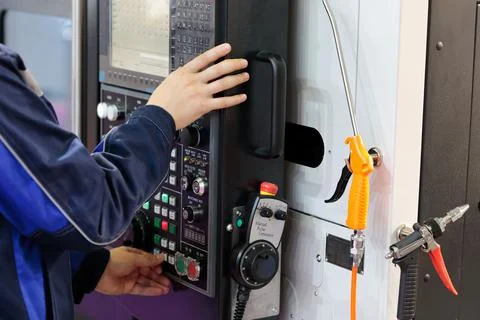 Worker adjusts the parameters of the CNC machine Stock Photos