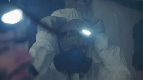 Worker adjusts safety gear in deteriorated building. Team member equips Stock Footage 346521899