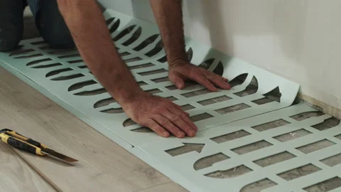 Worker Aligning Foam Underlayment Sheets on Floor Stock Footage 322055783