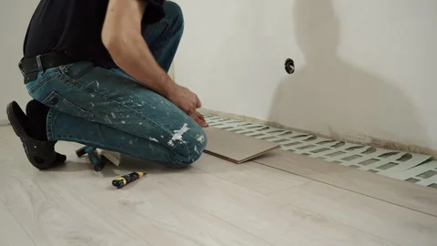 Worker Aligning Laminate Flooring on Foam Underlayment Stock Footage 322055429