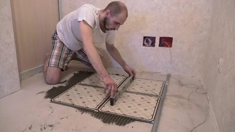 Worker aligns floor tiles on the floor Stock Footage 74061858