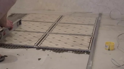Worker aligns floor tiles on the floor Stock Footage 74062799