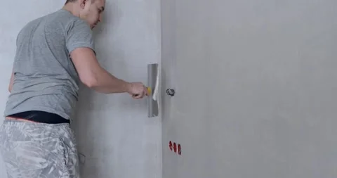 Worker aligns the wall with construction putty, close shot at builder hands Stock Footage 130366346