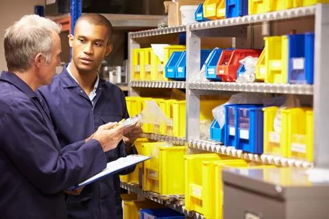 Worker and apprentice checking stock levels in store room Stock Photos