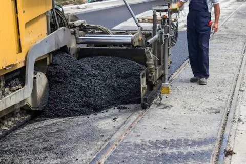 Worker and ashphalt paving machine Stock Photos