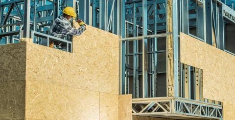Worker and Construction Site. Skeleton Steel Frame Installation. Foto stock