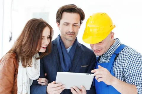 Worker and couple using tablet pc Stock Photos