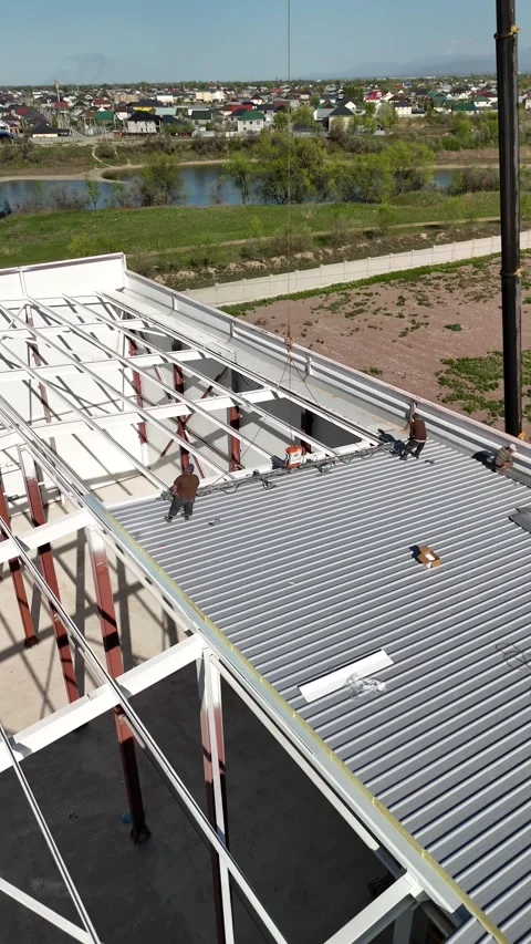 Worker and crane installing insulated wall panels on hangar Stock Footage 334972126