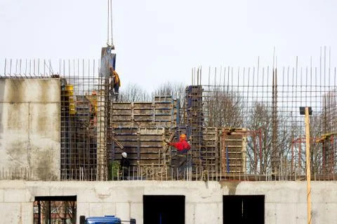 The worker and the crane operator unload the car with reinforced concrete wal Stock Photos
