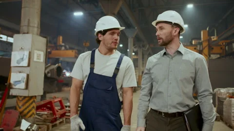 Worker and Engineer Walking through Factory, Discussing Manufacturing Process Stock Footage 296262413