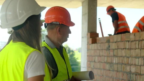Worker and engineers review work on building construction Stock Footage 317611594