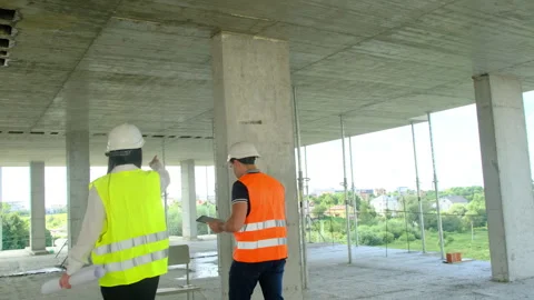 Worker and female engineer perform walkaround of building Stock Footage 317618580