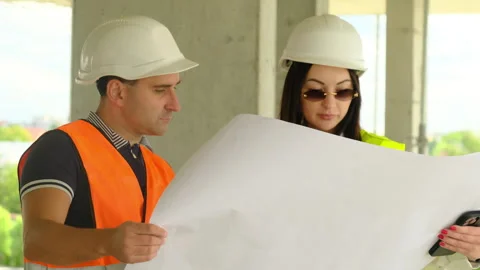 Worker and female inspector study layout in unfinished building Stock Footage 317620365